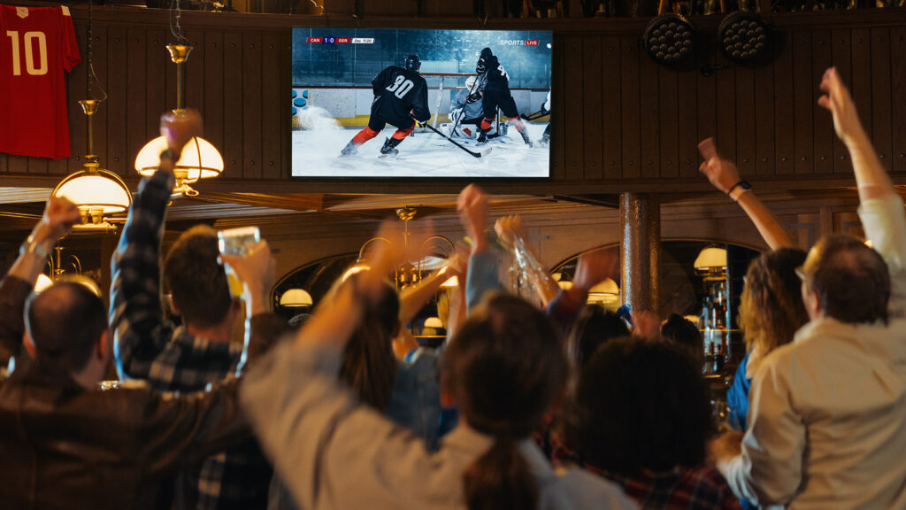 Fans at a pub watching hockey and cheering together